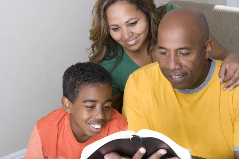 Husband and Father reading the Bible to his family. Husband and Father reading the Bible to his family.