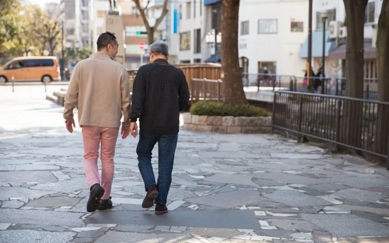 Two men walking alongside each other.